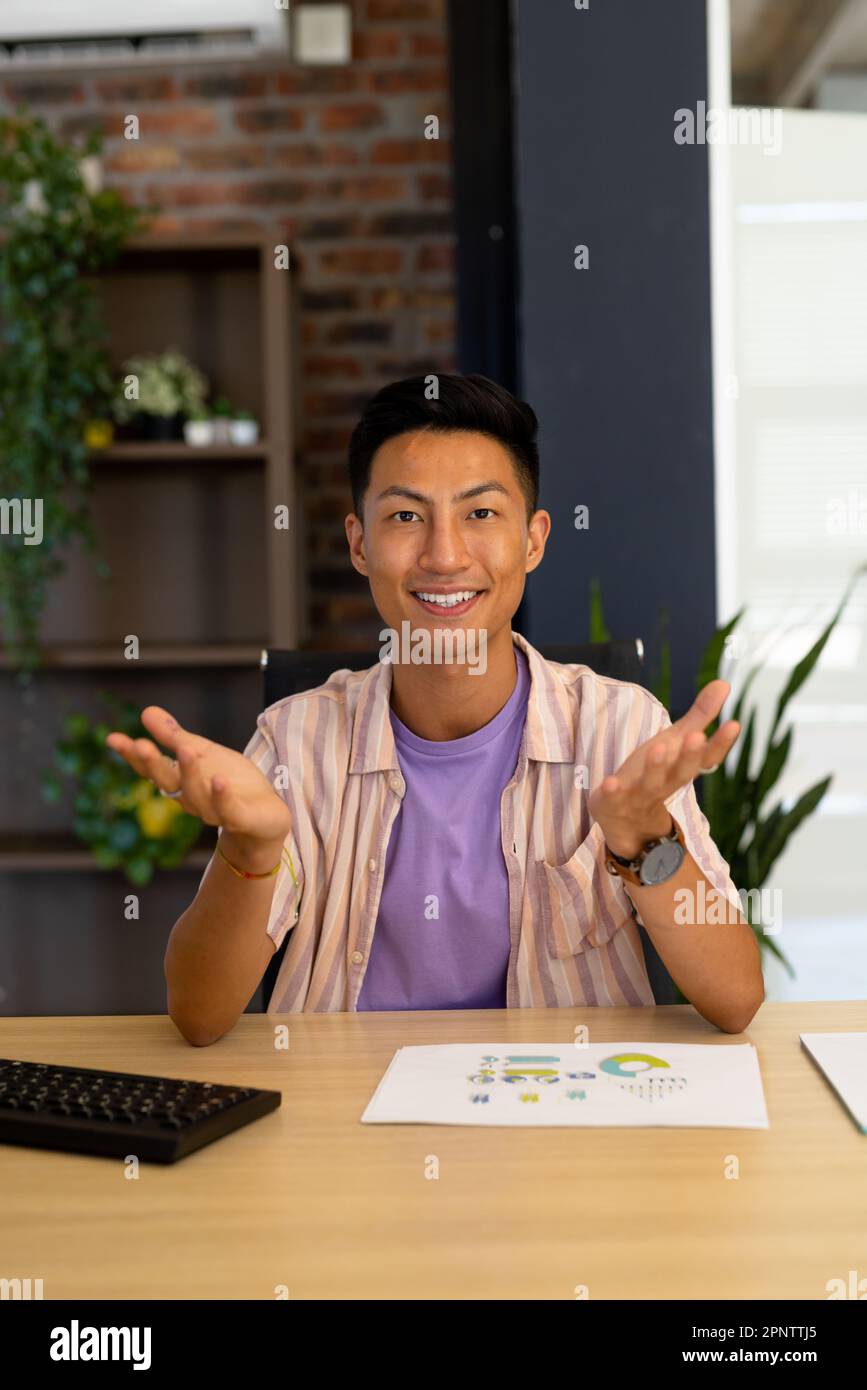 Portrait of happy asian casual businessman making video call smiling and gesturing, copy space Stock Photo