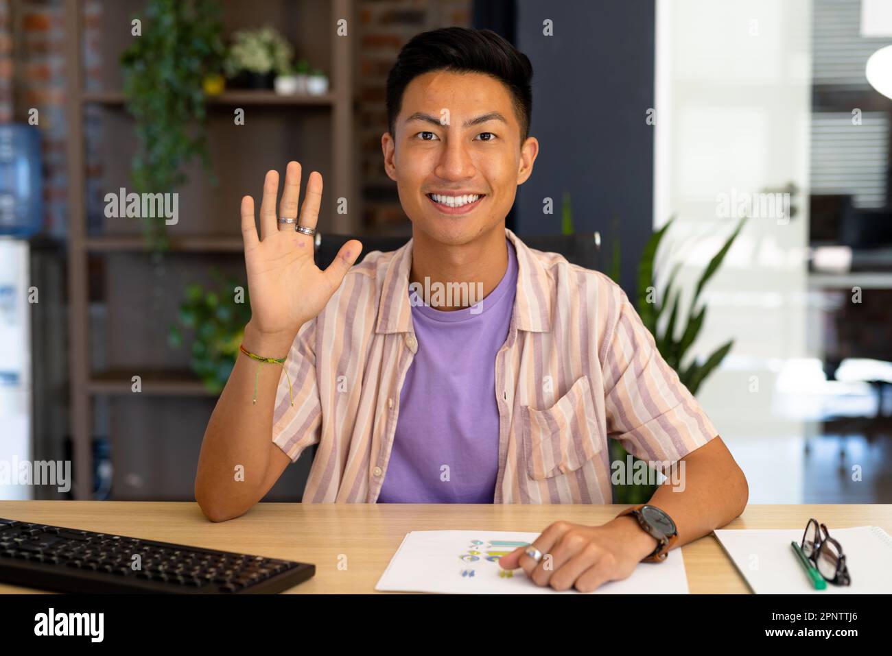 Portrait of happy asian casual businessman making video call smiling and waving Stock Photo