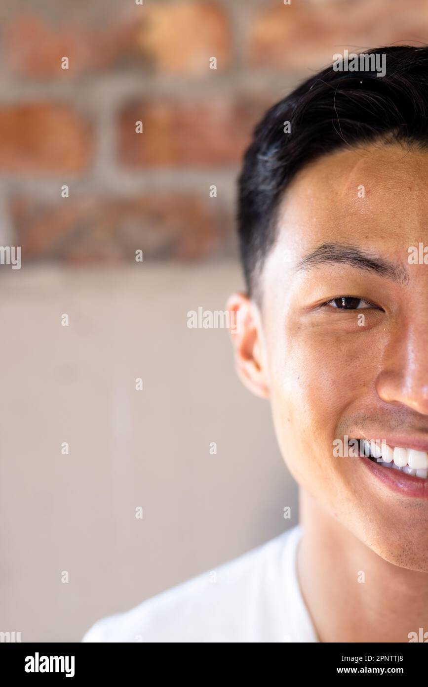 Half face portrait close up of happy asian casual businessman smiling, copy space Stock Photo