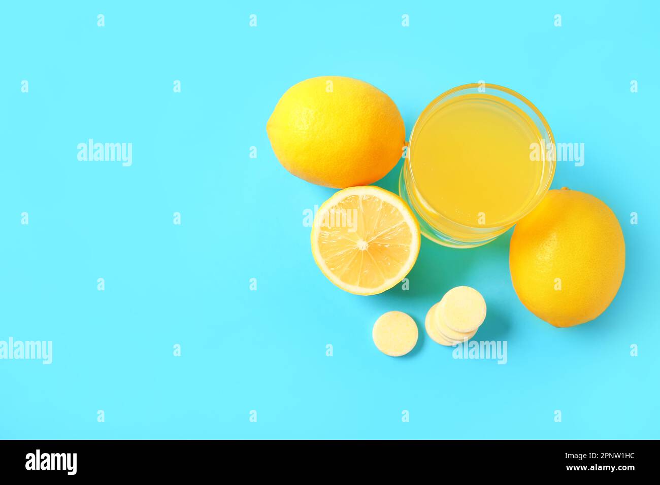 Glass of vitamin C effervescent tablet dissolved in water and lemons on