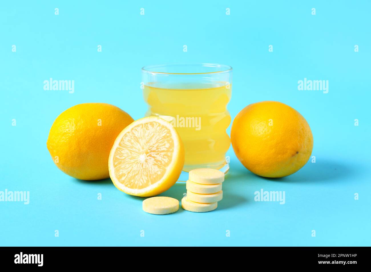 Glass of vitamin C effervescent tablet dissolved in water and lemons on