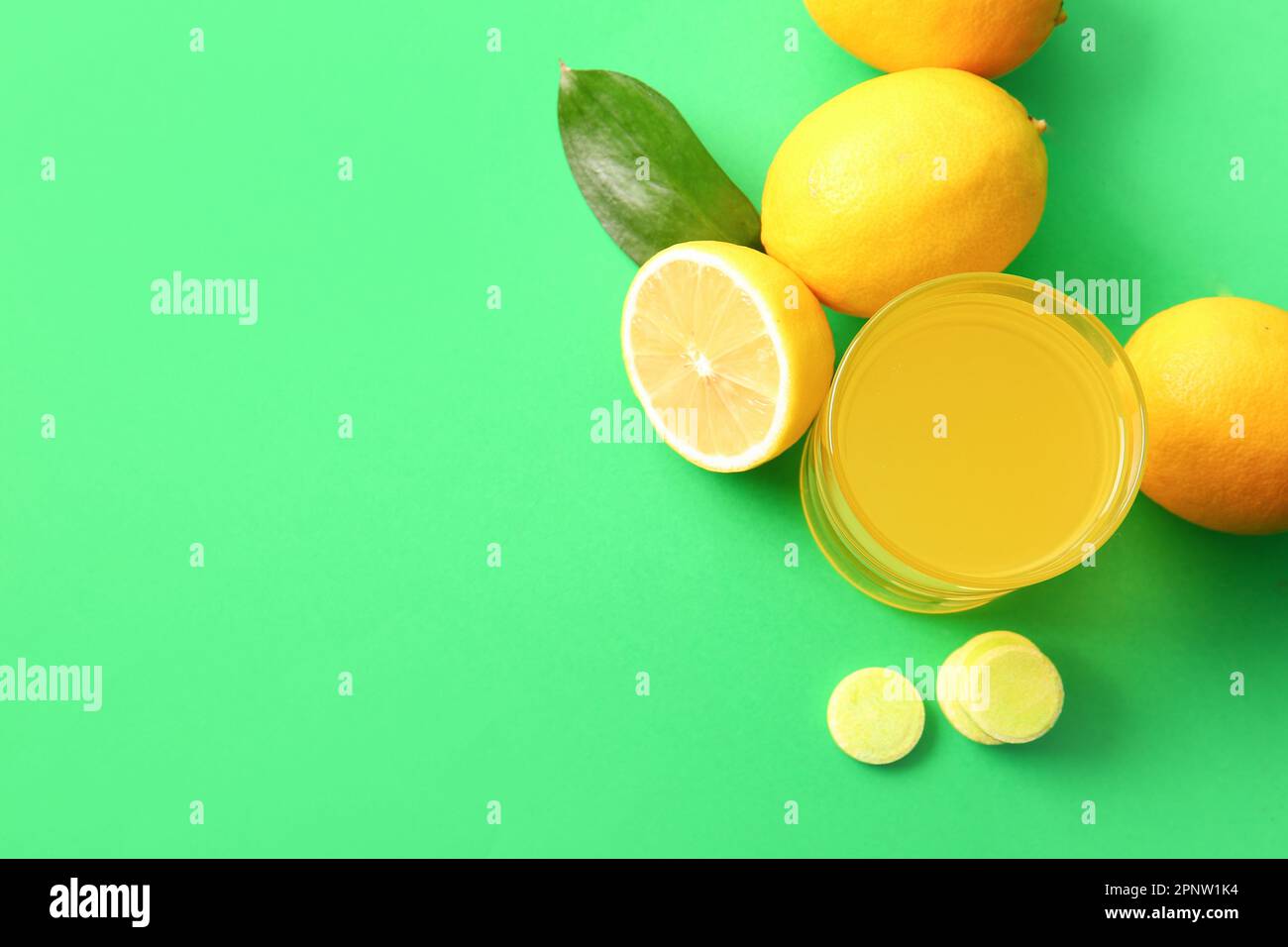Glass of vitamin C effervescent tablet dissolved in water and lemons on