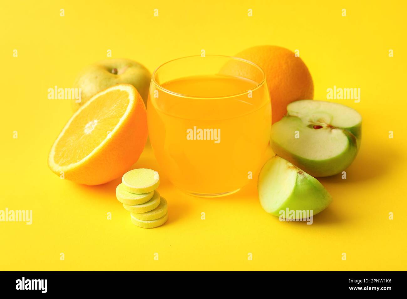 Glass of vitamin C effervescent tablet dissolved in water and fruits on