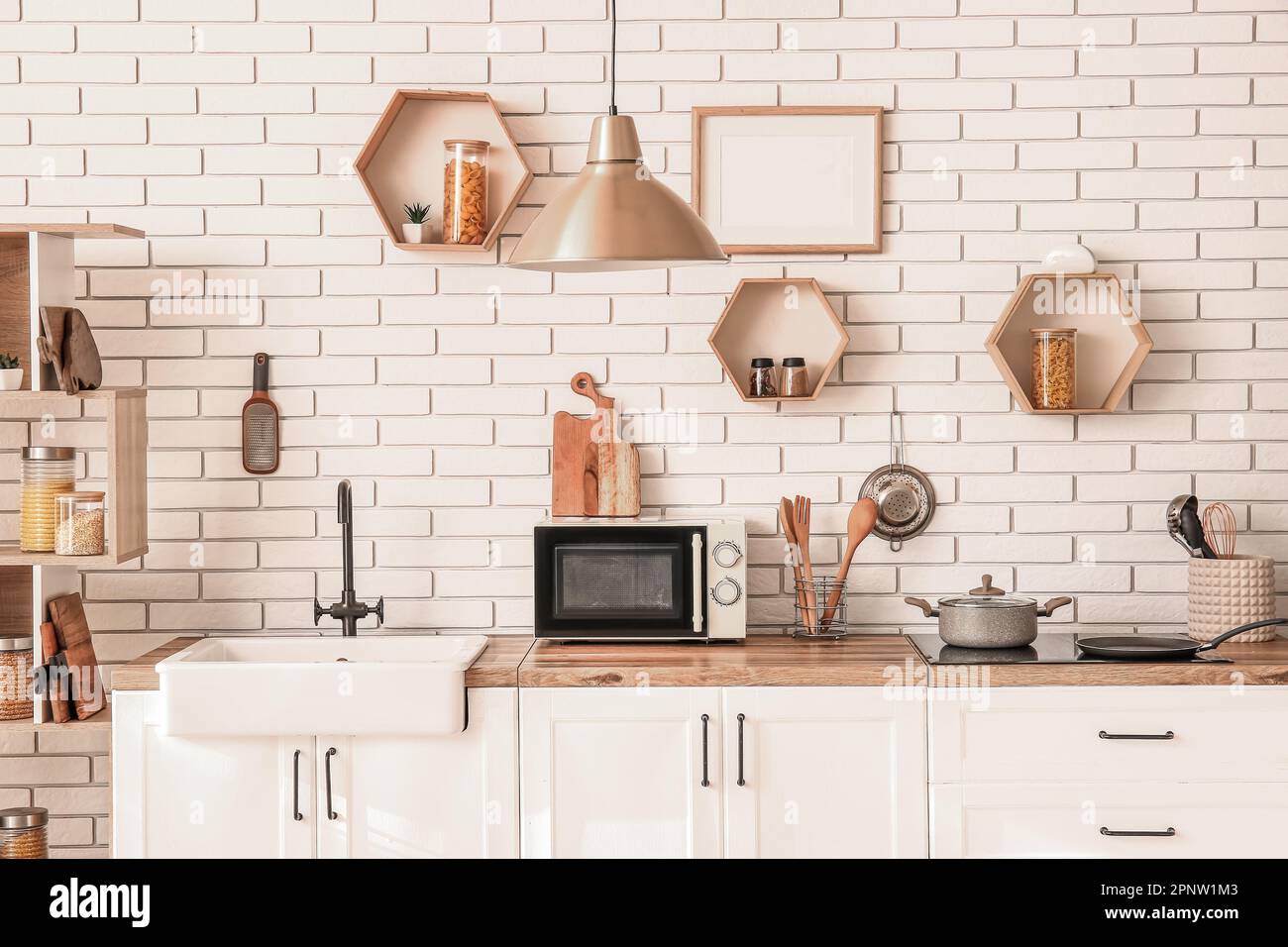 Interior of modern kitchen with sink, microwave oven and cooking pot on ...