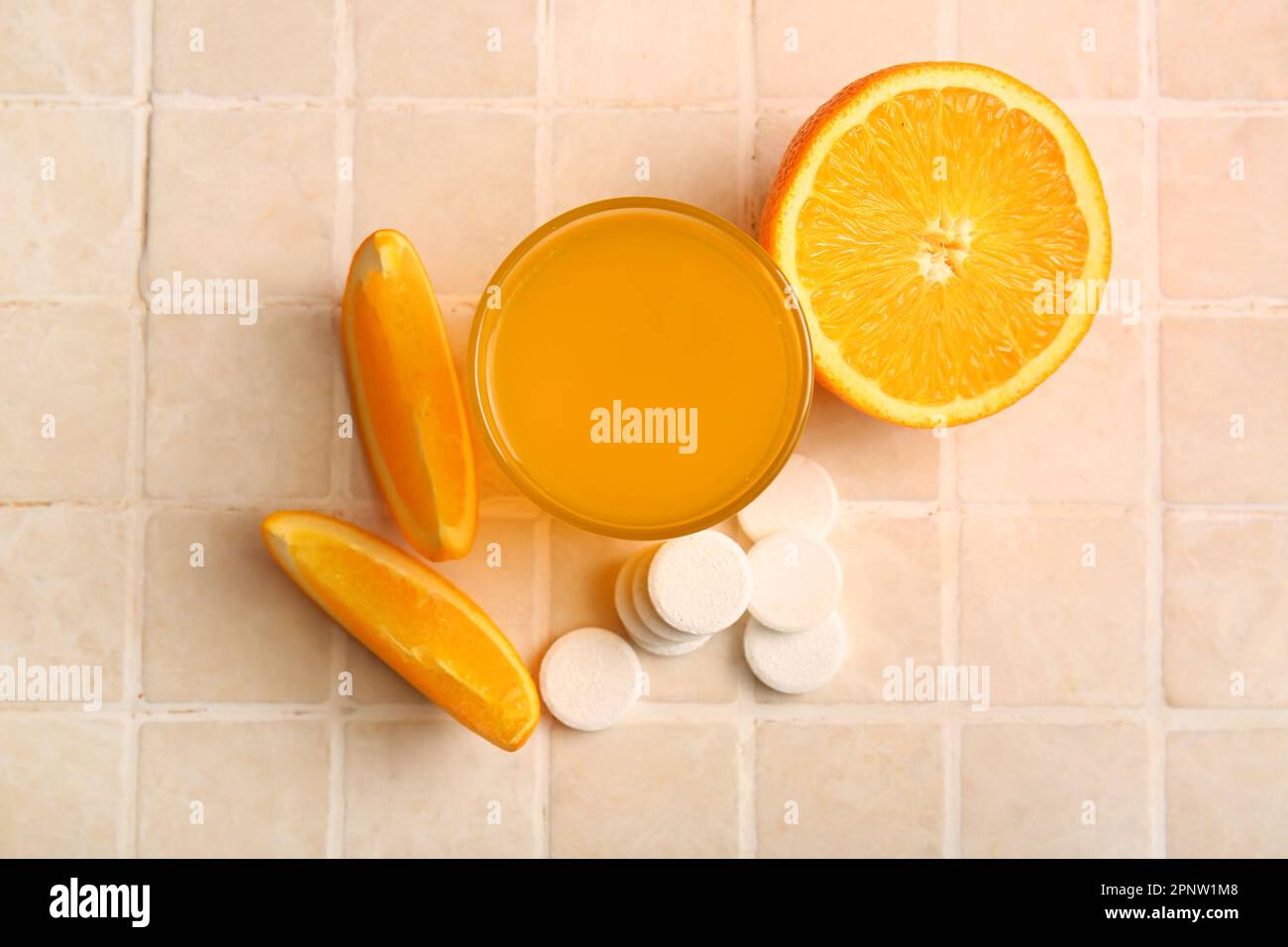 Glass of vitamin C effervescent tablet dissolved in water and orange on
