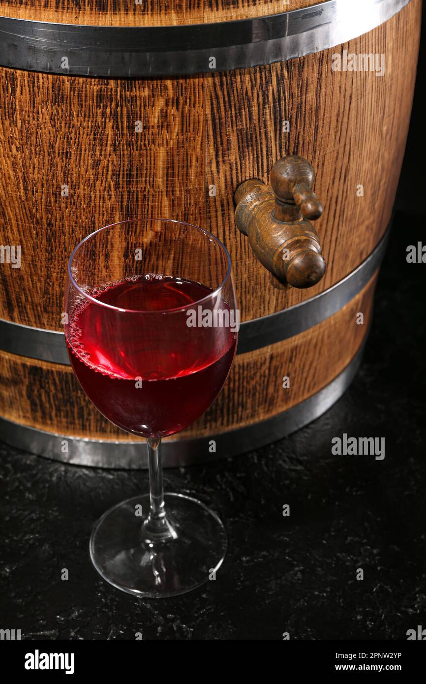Wooden barrel with glass of wine on dark background Stock Photo - Alamy