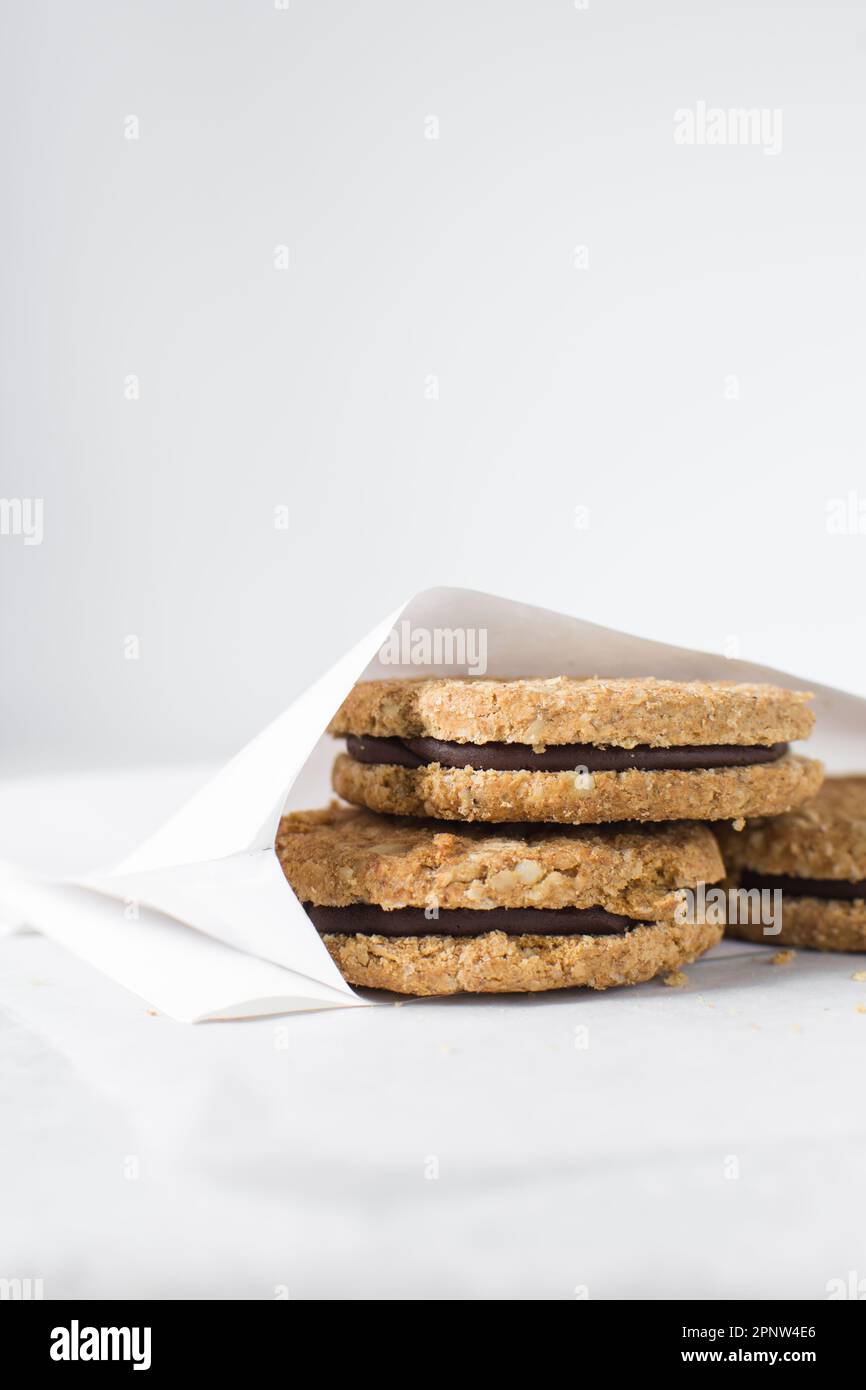 cookies packed in white parchment bags, chocolate filled oat cookies in