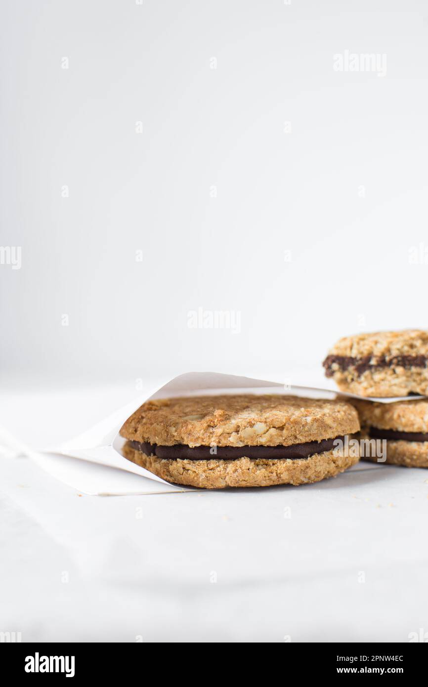 cookies packed in white parchment bags, chocolate filled oat cookies in