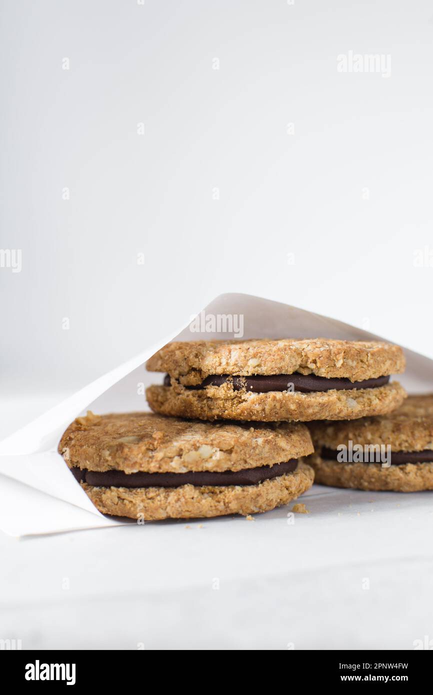 cookies packed in white parchment bags, chocolate filled oat cookies in