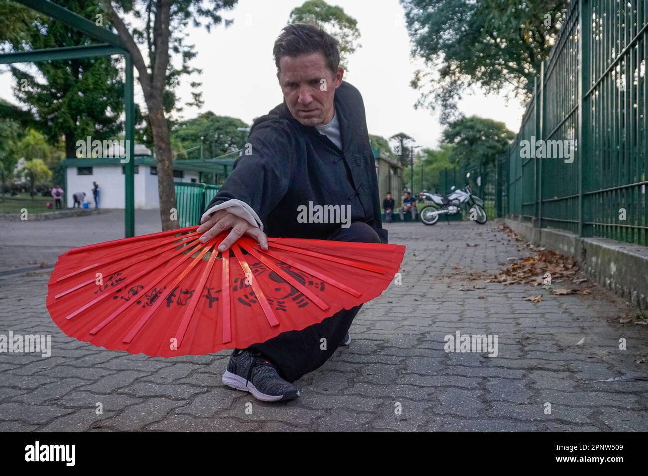 Patricio Zanet performs Wudang-style kung fu with a fan at Parque Centenario in Buenos Aires, Argentina on April 21, 2022. Zanet says this martial art, which encourages well-being of the body, mind and spirit, represents integrity. (Lucila Pellettieri/Global Press Journal) Stock Photo