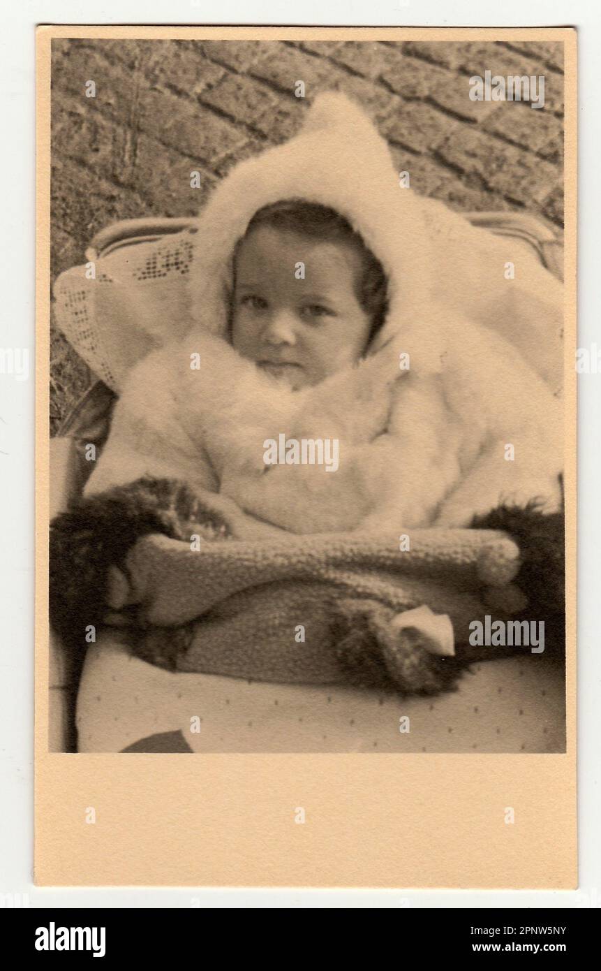 HODONIN, THE CZECHOSLOVAK REPUBLIC, CIRCA 1940: Vintage photo shows a baby girl in a pram - baby carriage, circa 1940. Stock Photo