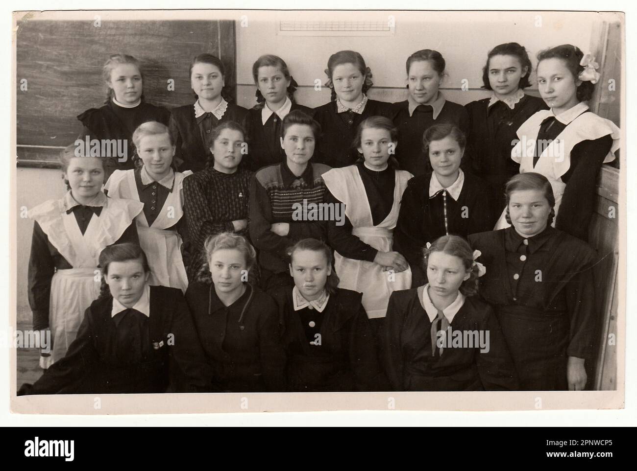 Vintage photo shows schoolmates - girls and their female teacher. Stock Photo