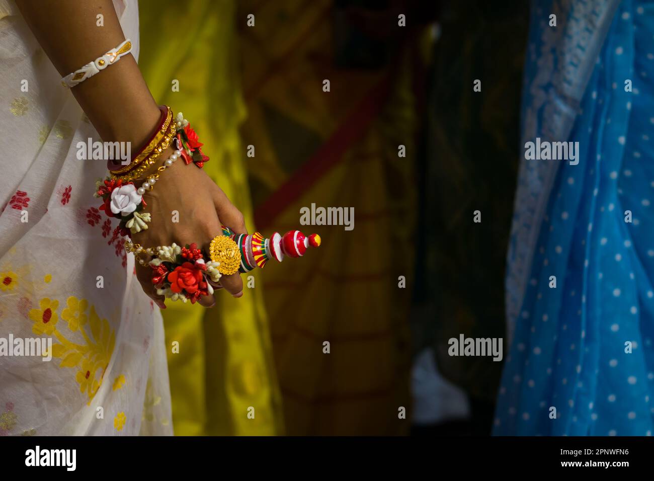 Bride holding gaachh kouto during wedding rituals of traditional