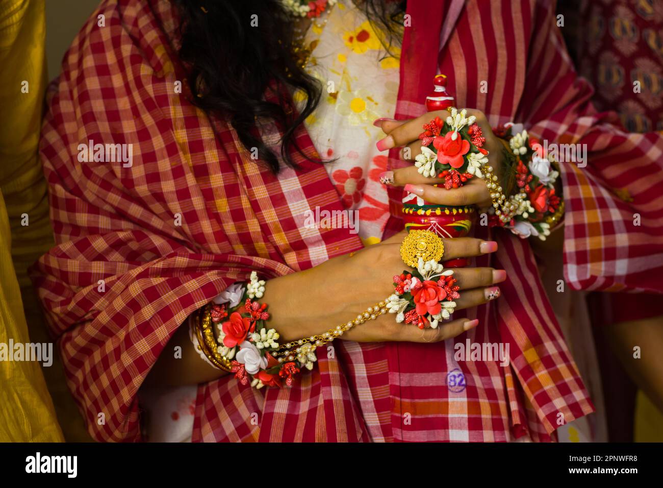 Bride holding gaachh kouto during wedding rituals of traditional