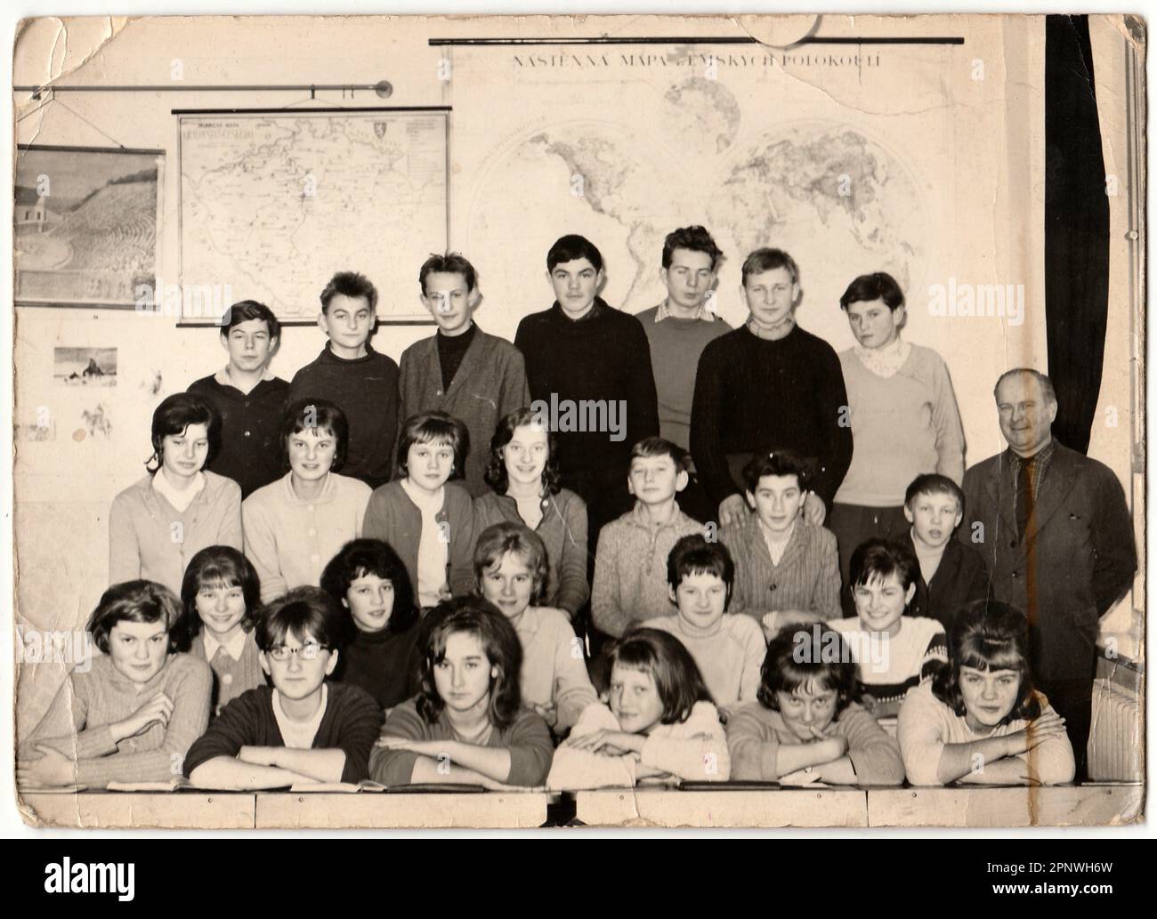 Retro photo shows students with male teacher in the classroom. Stock Photo