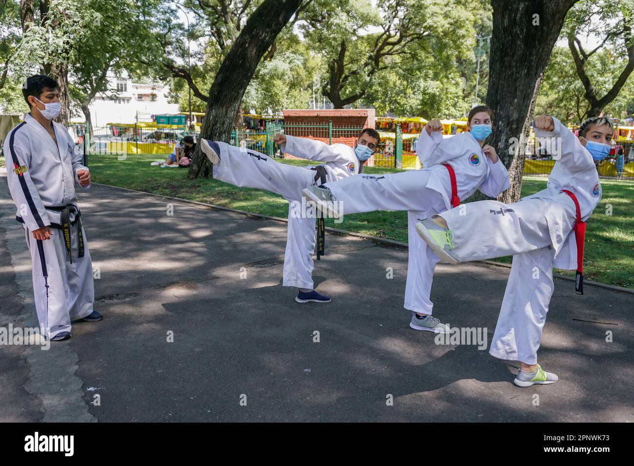 Héctor Avedaño, far left, instructs, from left, Nahuel Deleva, Diana Gómez and Iara Bustamante in Buenos Aires, Argentina on February 19, 2022. Avedaño, who started teaching taekwondo outdoors during the coronavirus pandemic, now offers lessons both indoors and at parks. (Lucila Pellettieri/Global Press Journal) Stock Photo
