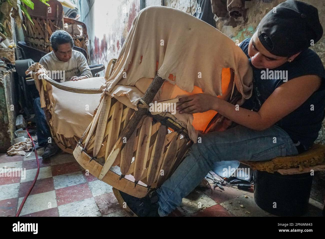 Raúl Sánchez, left, and Miguel Ángel Martínez make equipales, traditional Mexican chairs, using padding and pigskin in Guadalajara, Jalisco, Mexico on January 18, 2022. Sánchez says the trade has been difficult because many people don’t value handmade equipales and would rather buy cheaper goods. (Maya Piedra/Global Press Journal) Stock Photo