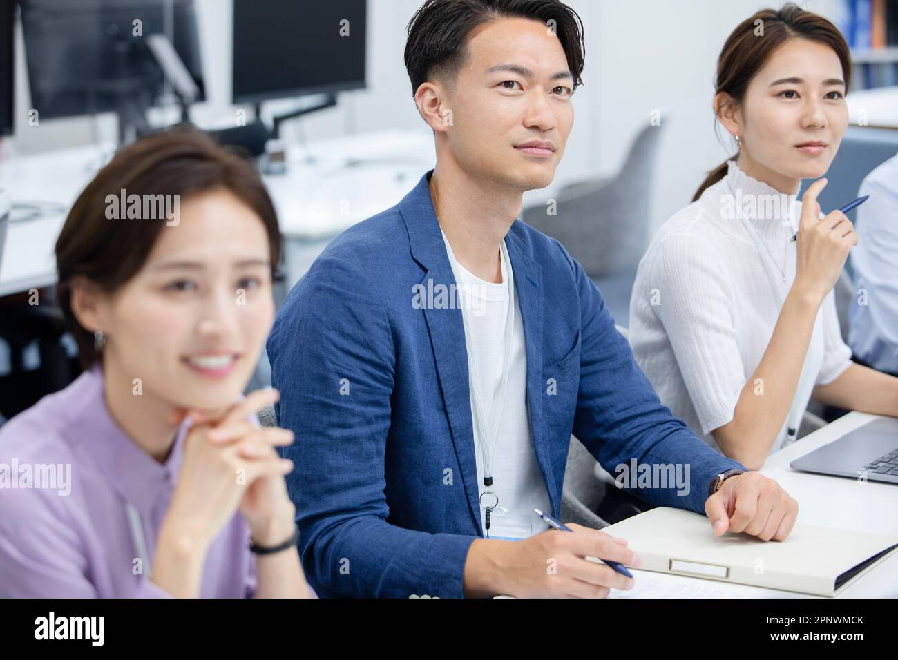 Businessmen and businesswomen standing side by side in a conference room Stock Photo