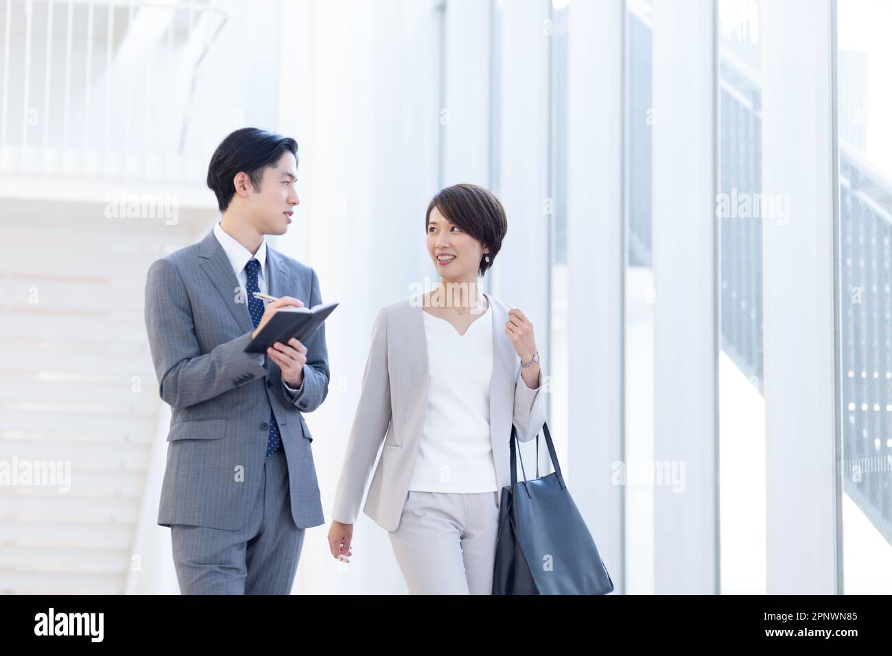 Businessmen and businesswomen walking in the lobby Stock Photo - Alamy
