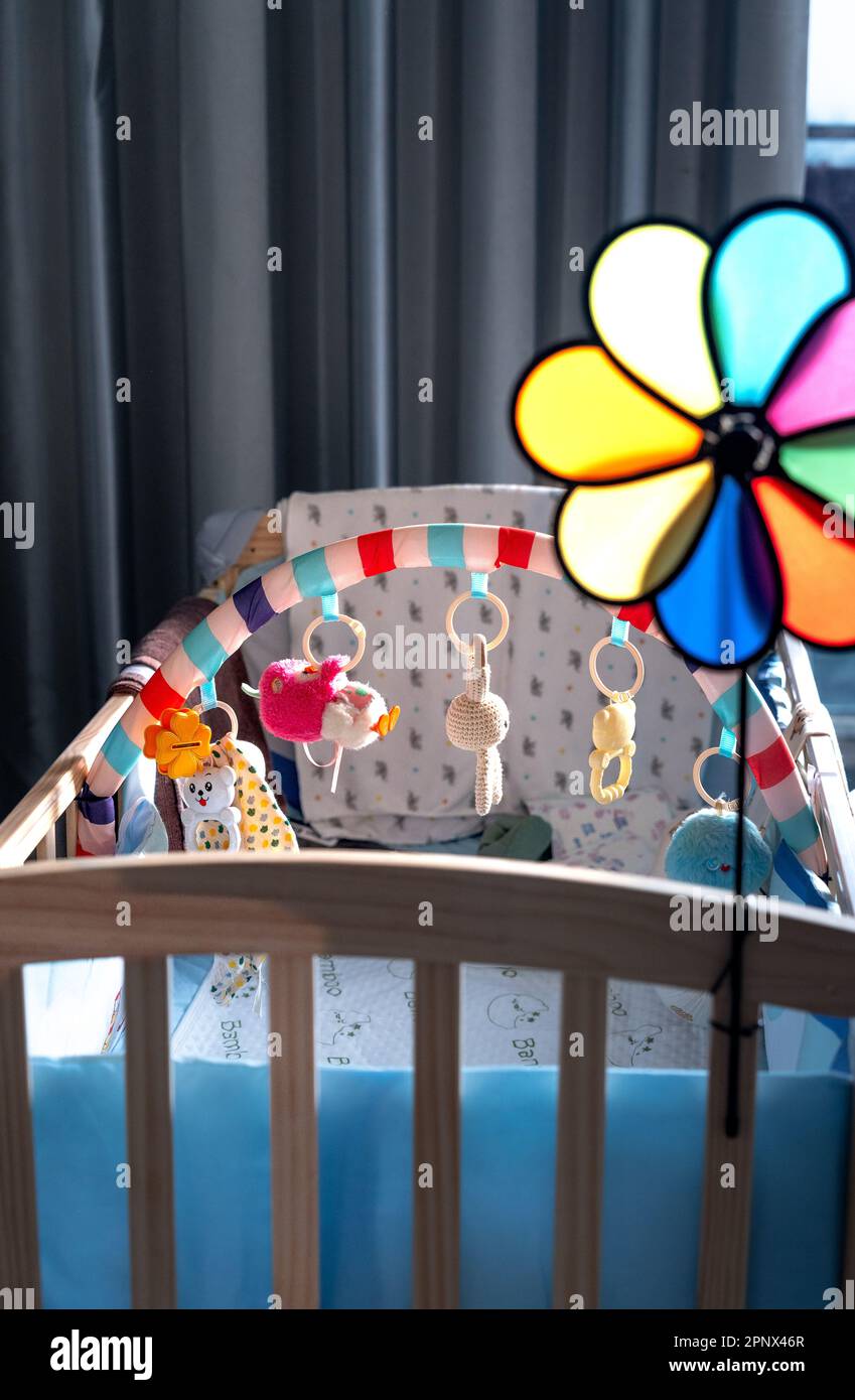 Portable baby crib. Toys above the baby's crib. Hanging cute little toy teddy bears for the