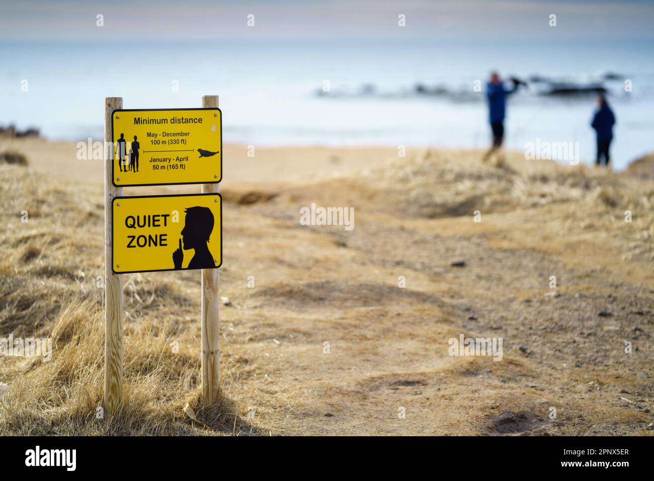 Yellow warning signs, Quiet Zone and Keep your distance posted at Ytri Tunga Beach in Snæfellsnes Peninsula, Iceland. Stock Photo