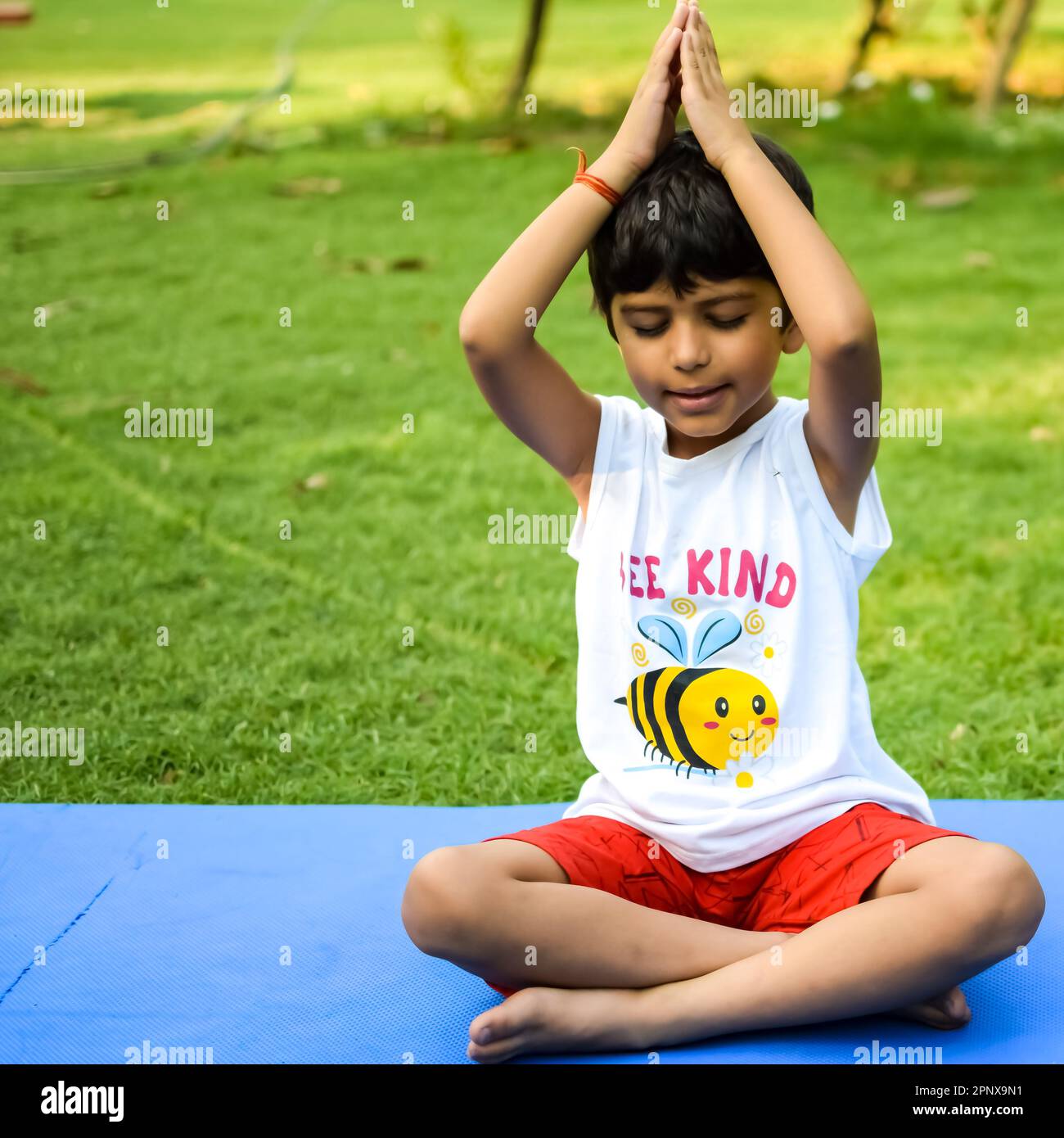 Asian smart kid doing yoga pose in the society park outdoor, Children's