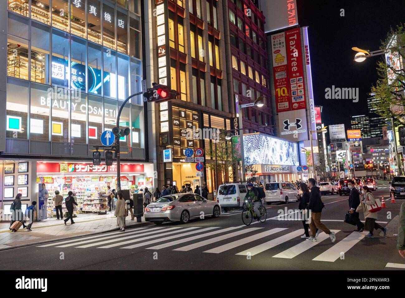 April 2023 Shinjuku Tokyo evening time and crowds and neon lights keep the city alive, zebra and pelican crossings street scene Japan,Asia Stock Photo