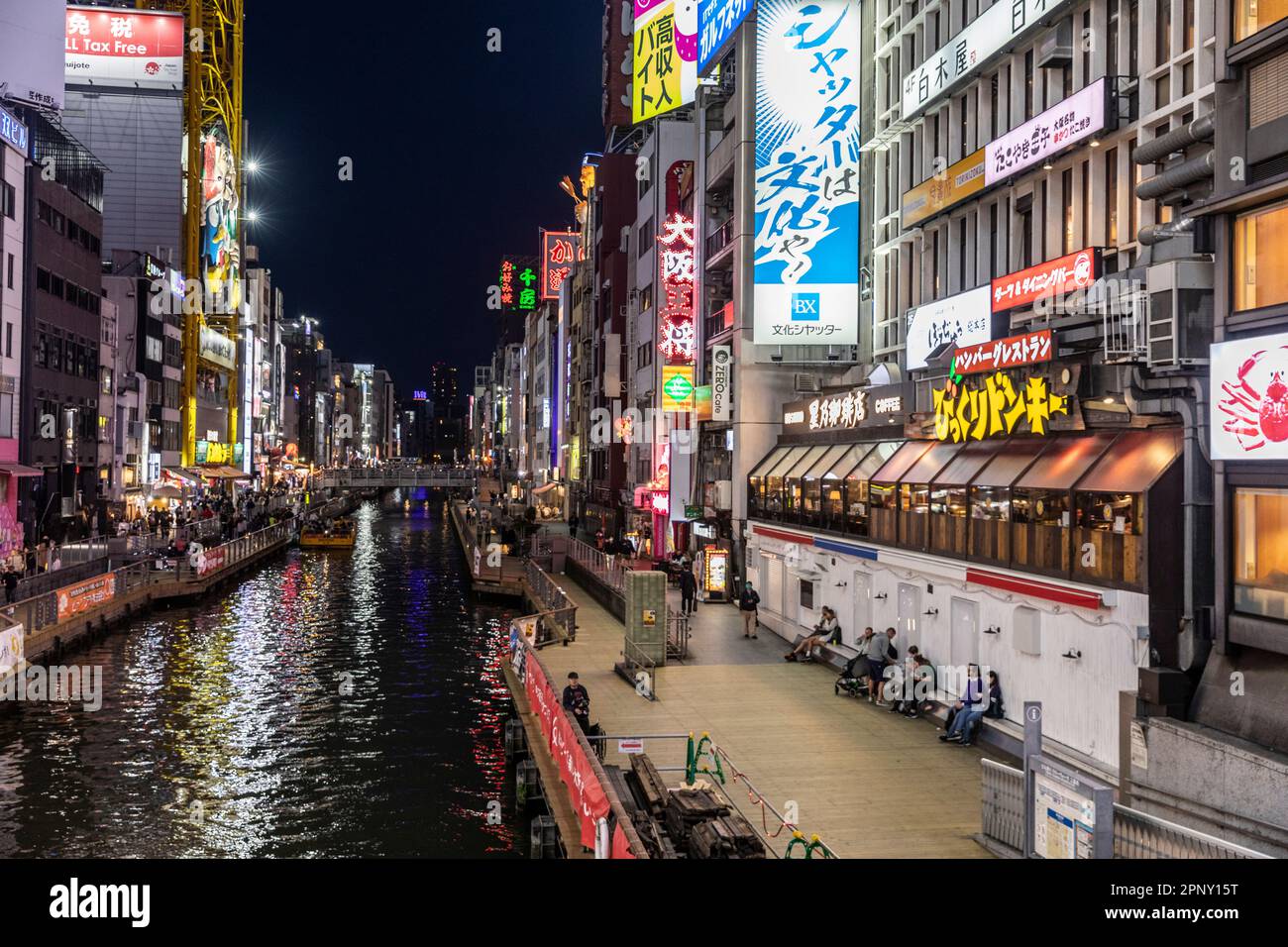 Osaka Japan April 2023, Dotonbori River canal at night time with neon lights and crowds gathering for dinner and entertainment, street scene,Japan Stock Photo