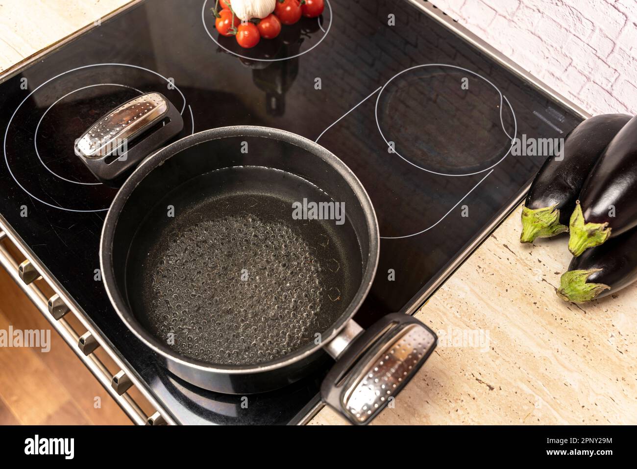 a pot of boiling water on an electric stove in the kitchen Stock Photo
