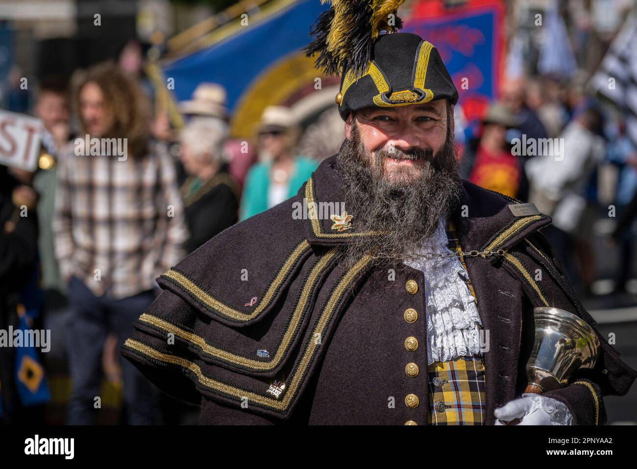 A smiling Philip Northcott the official Penzance Pensans Town Crier in full regalia and carrying his handbell in Cornwall in the UK. Stock Photo