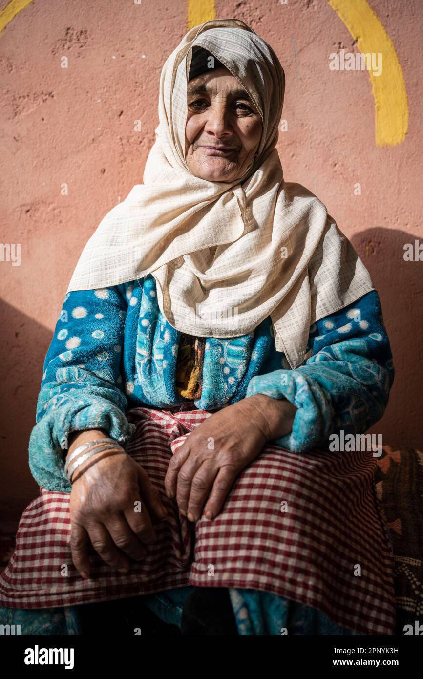 Portrait of a Berber lady sitting next to the symbol of freedom. Stock Photo