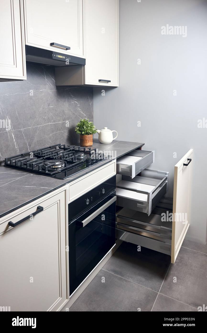 Gas cooker black glass and iron hob and hood on marble light stoneware