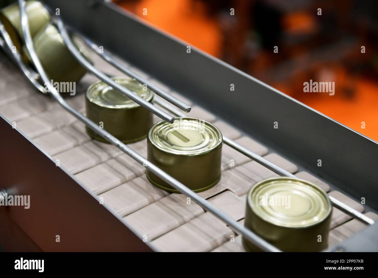 Canned food products on conveyor belt in distribution warehouse