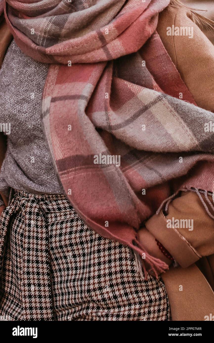 Fashion details of autumn stylish brown coat, scarf and plaid pants. Female casual street style outfit Stock Photo