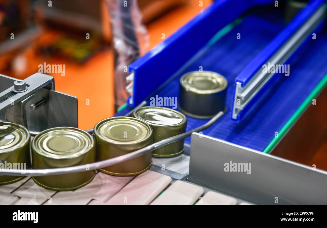 Canned food products on conveyor belt in distribution warehouse