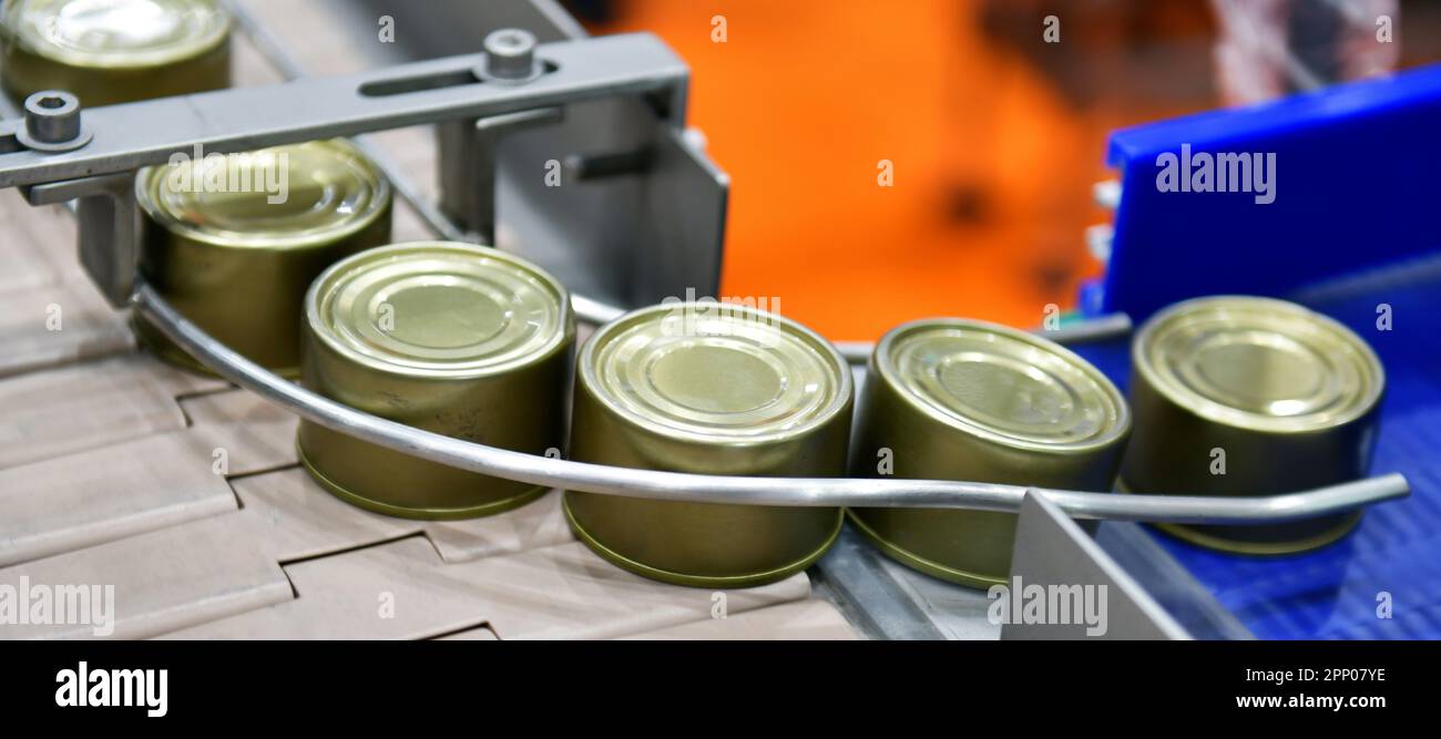 Canned food products on conveyor belt in distribution warehouse