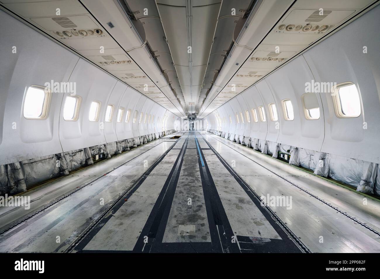 Commercial airplane under heavy maintenance. Inside of passenger cabit without seats and interior. Stock Photo