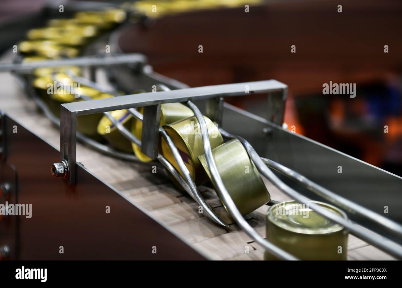 Canned food products on conveyor belt in distribution warehouse
