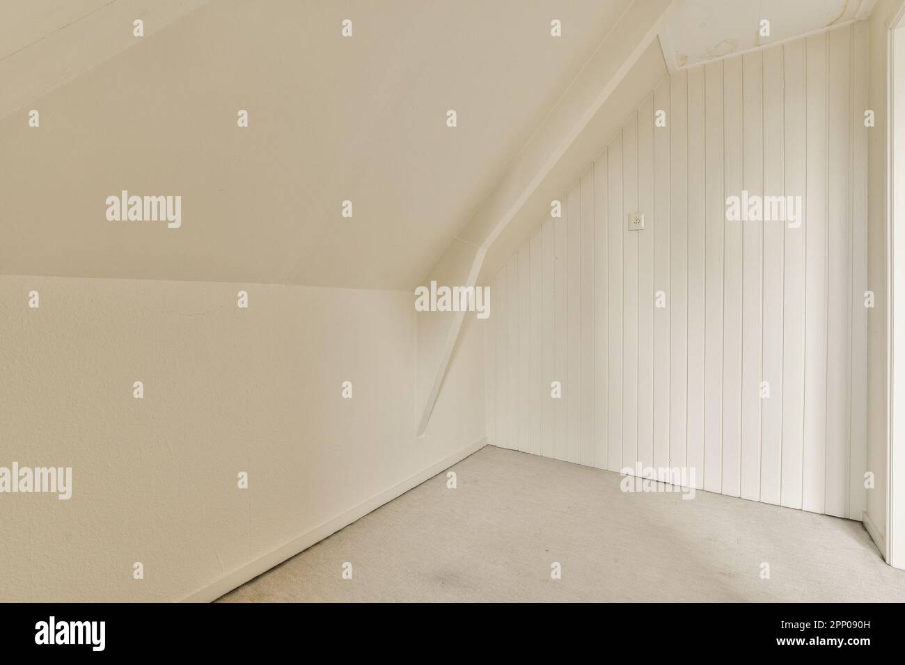 an empty room with white walls and wood paneled doors on either side of the room, there is a door in the corner Stock Photo