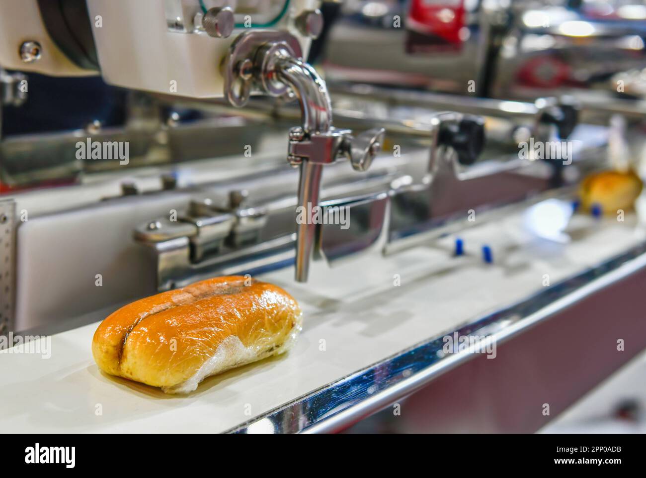 Automatic hamburger buns production line on conveyor belt equipment machinery in factory, industrial food production. Stock Photo