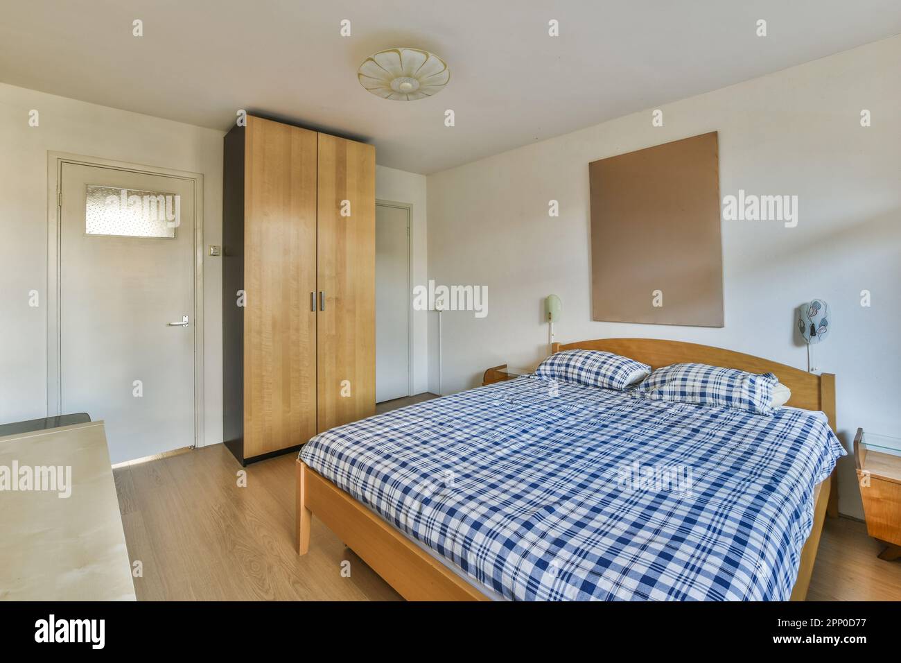 a bedroom with a blue and white checkered comforter on the bed in front