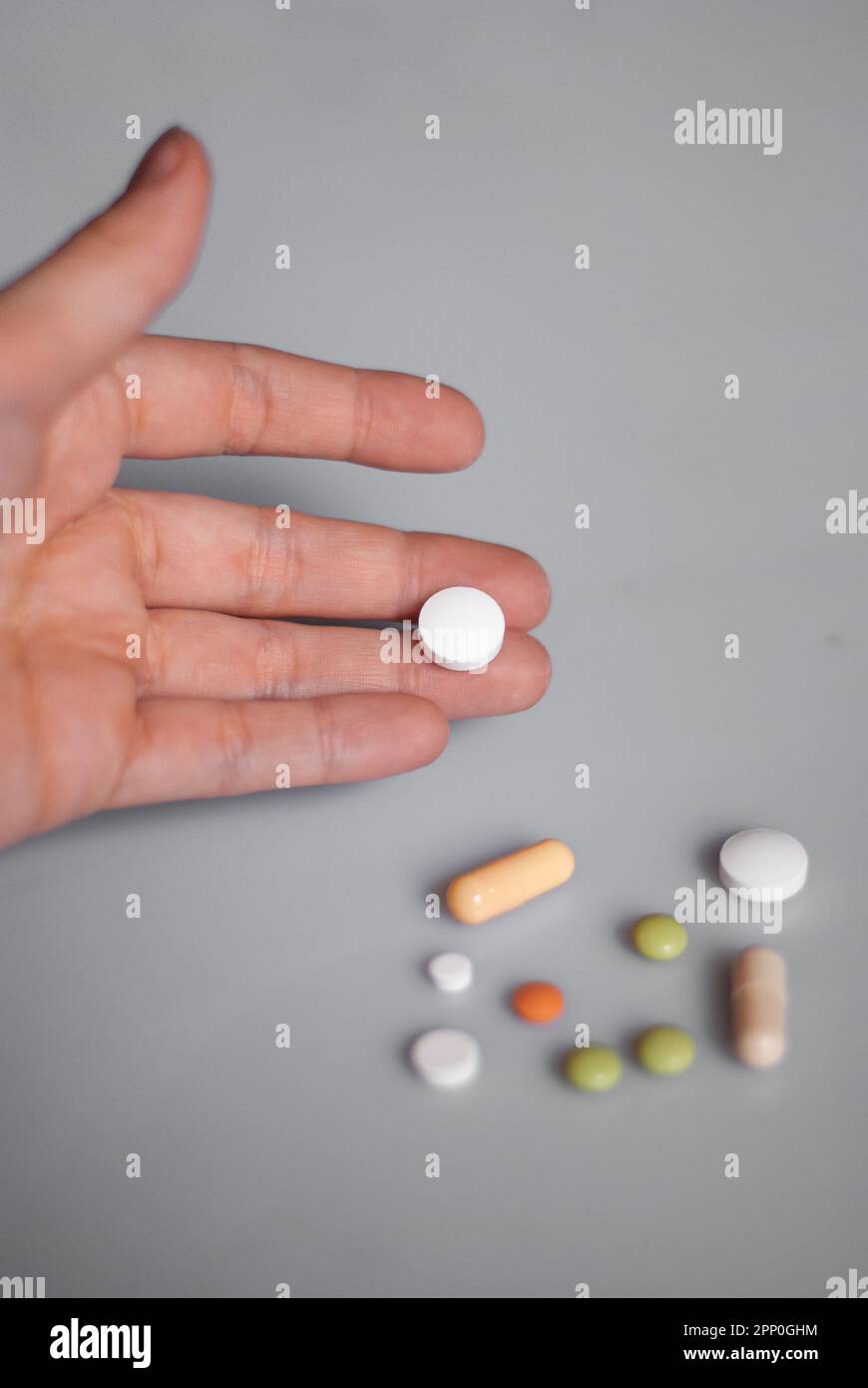 View of white pill on a hand on the white background Stock Photo