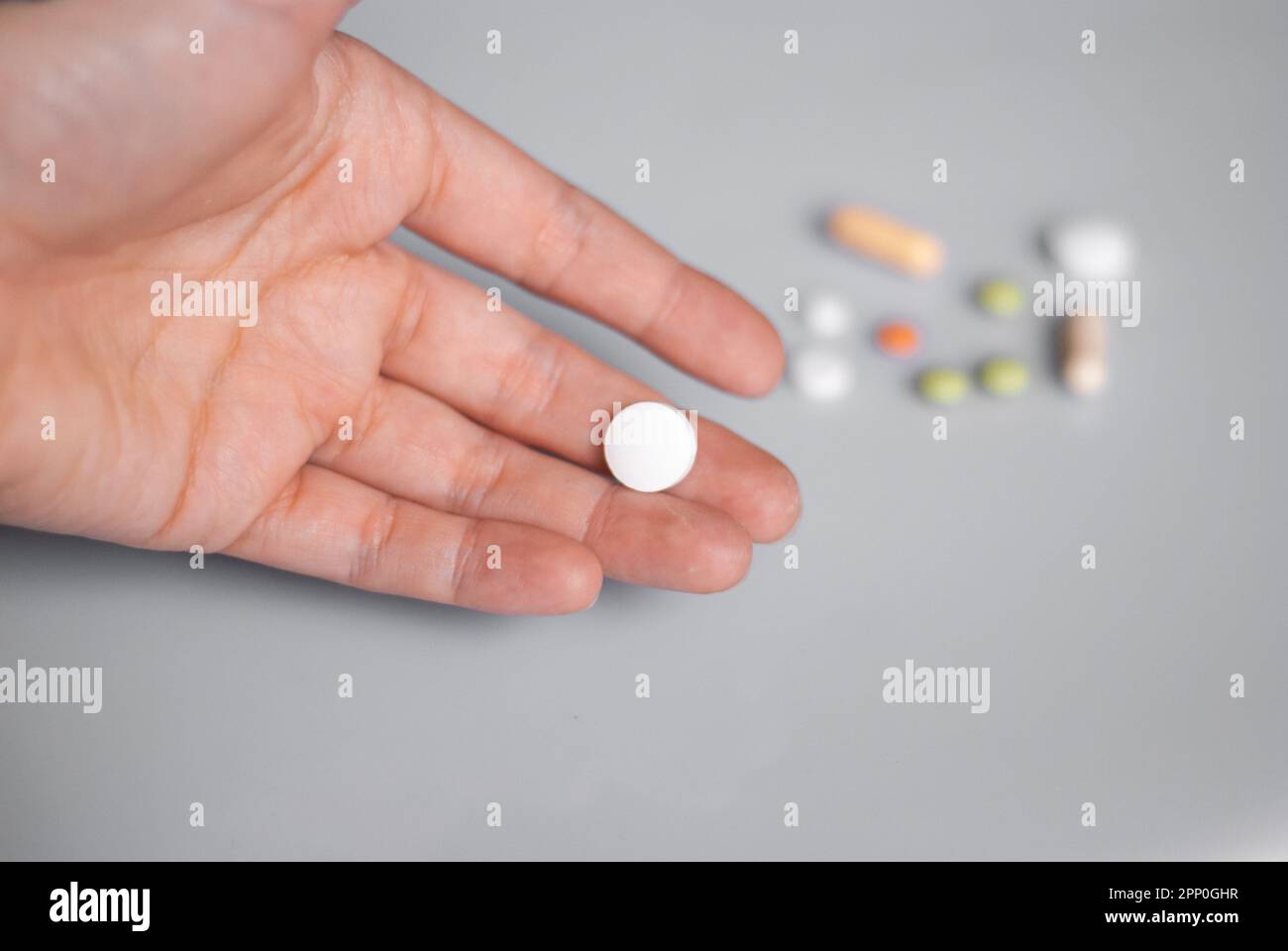 White pill on a hand on the white background Stock Photo