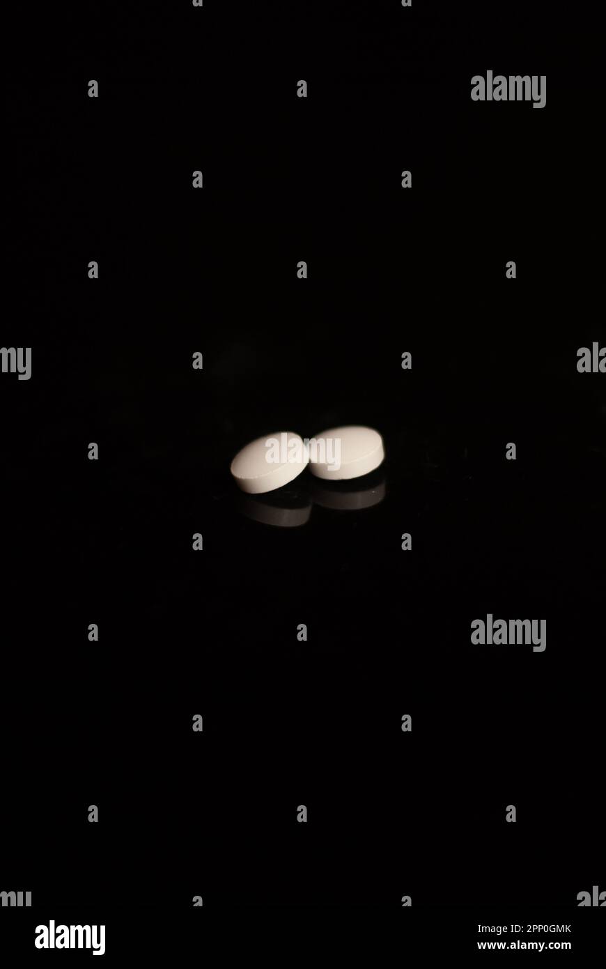 Close up of white pills on the black background Stock Photo