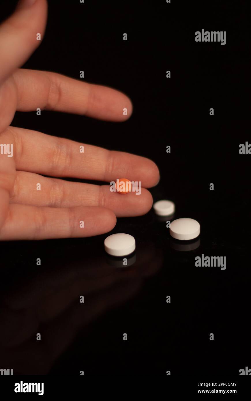 View on red pill on a hand on the black background Stock Photo