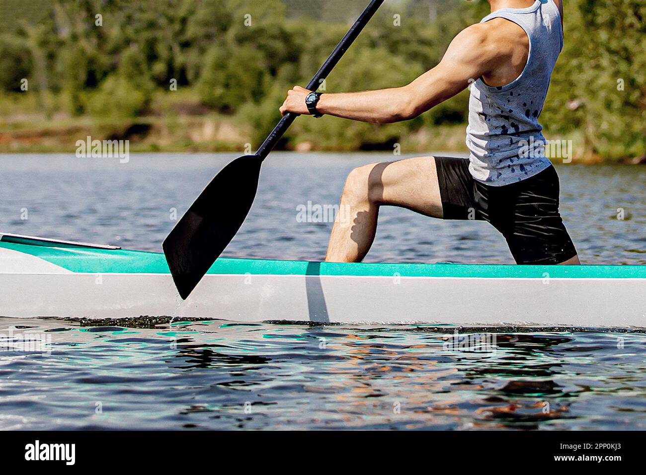 close-up man canoeist on canoe single rowing training on lake Stock Photo