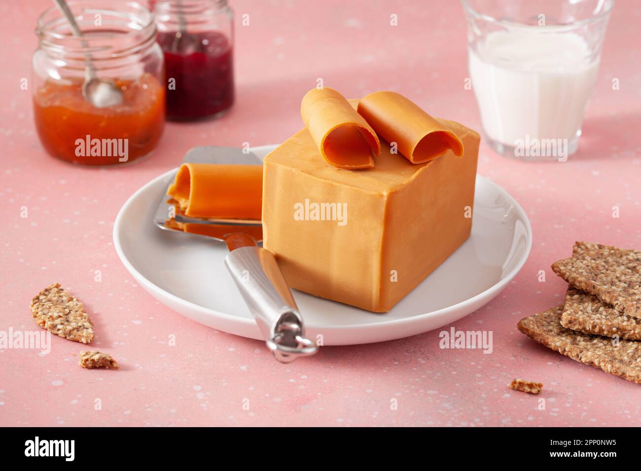 https://c8.alamy.com/comp/2PP0NW5/norwegian-brunost-traditional-brown-cheese-block-and-slicer-2PP0NW5.jpg