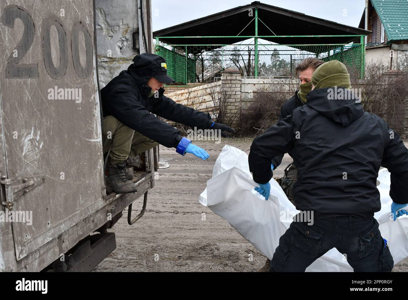 The Black Tulip group members are loading a plastic bag with the remains of Russian soldier, killed in battles and abandoned by the Russian troops, in a van in Sviatohirsk. The Black Tulip NGO (Non-Governmental Organization), Ukraine was founded in the early 2010s to find and recover the remains of soldiers killed during the two world wars. But now the group is made up of about 100 volunteers and searching for victims of a contemporary war that started with a 2014 pro-Russian insurgency in Ukraine's east and engulfed the whole country after Moscow invaded on February 24. Black Tulip exhumes bo Stock Photo