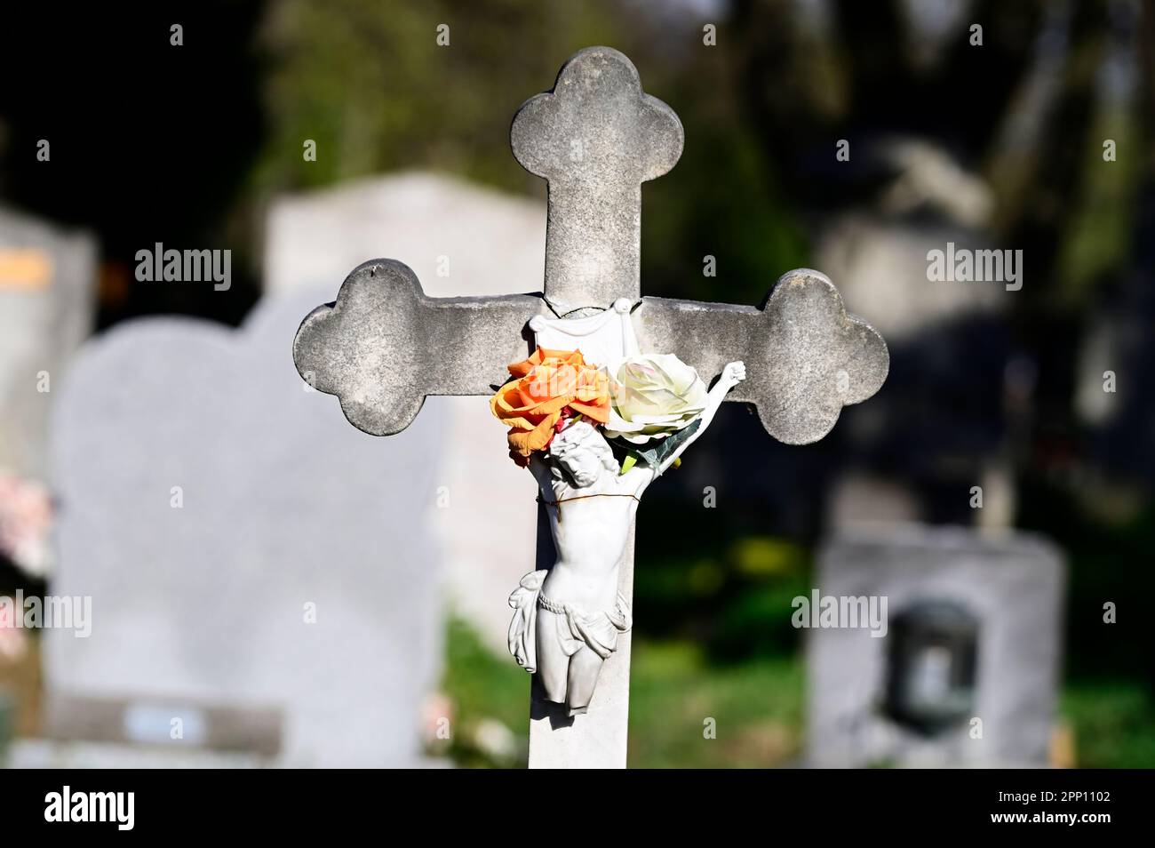 Vienna, Austria. Vienna Central Cemetery. Old stone cross with Jesus figure and flowers Stock Photo