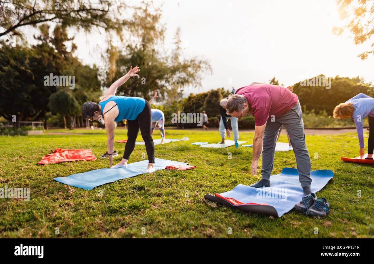 Happy senior friends doing workout activity in a public park - Health elderly people lifestyle Stock Photo